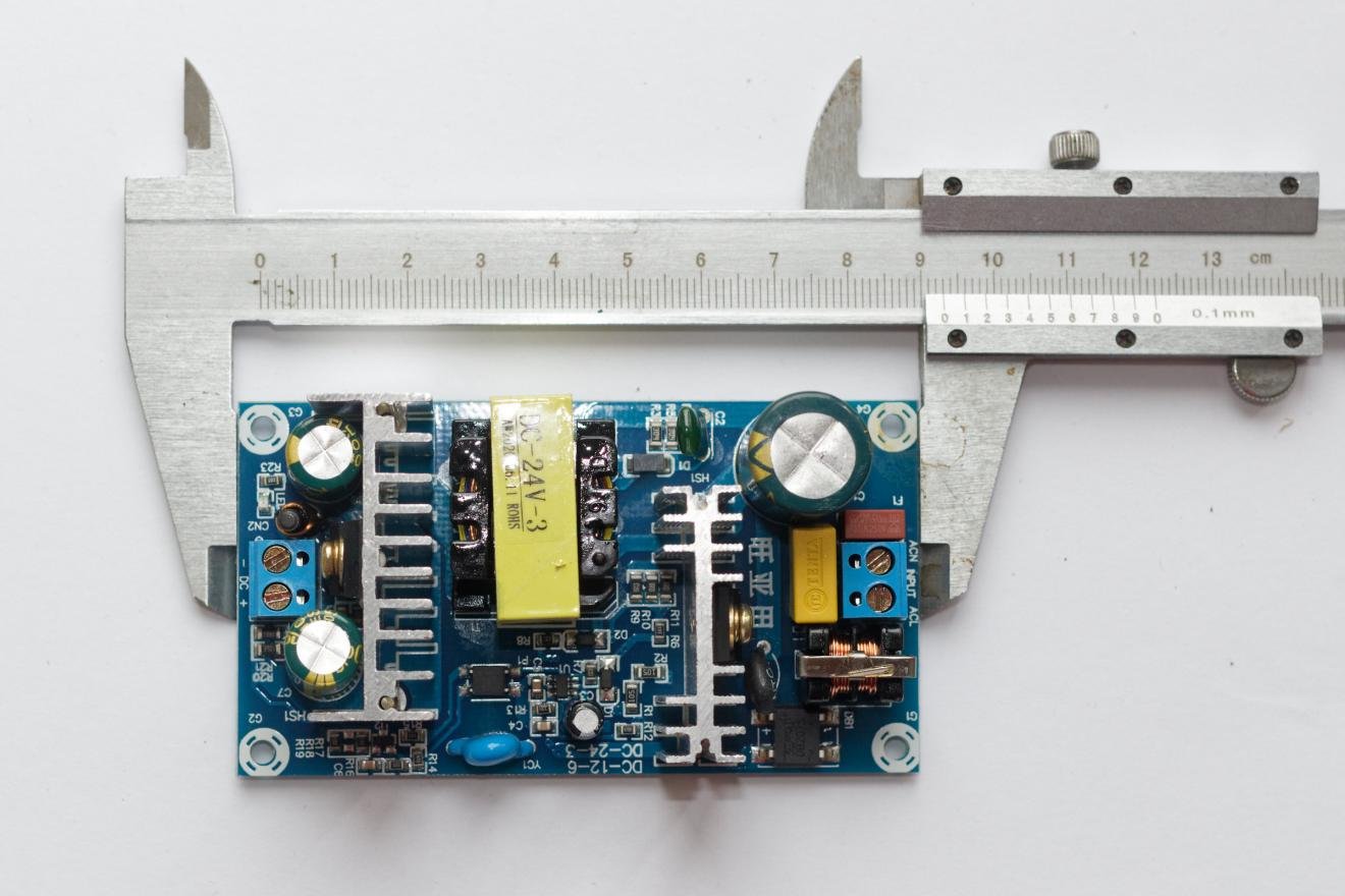 Open-frame 24 V AC-DC switching power supply module with transformer and caliper