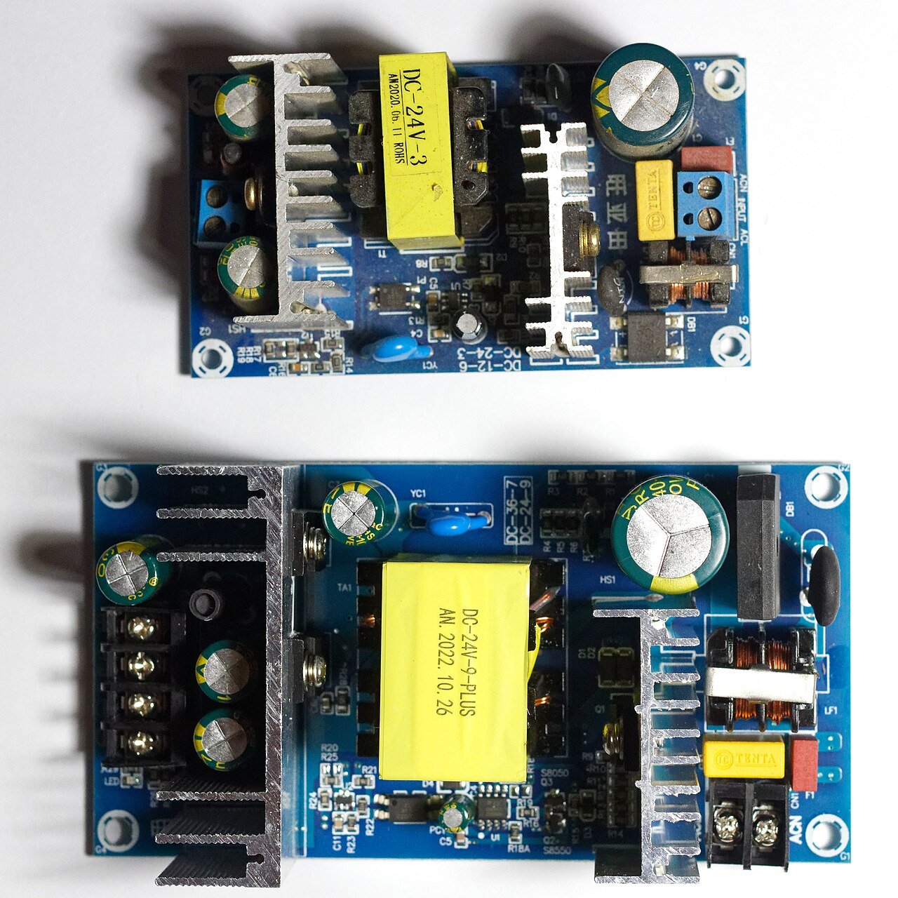 Clean AC-DC switching power supply boards showing transformers, output capacitors, terminals, and heatsinks