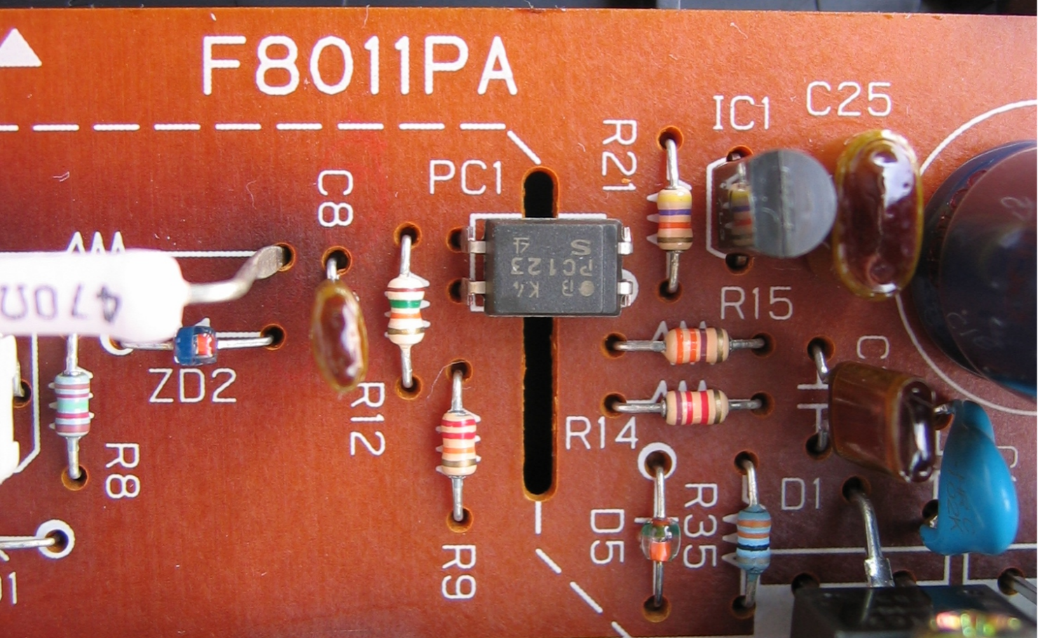 Optocoupler mounted in a power supply feedback area with nearby resistors and isolation spacing visible
